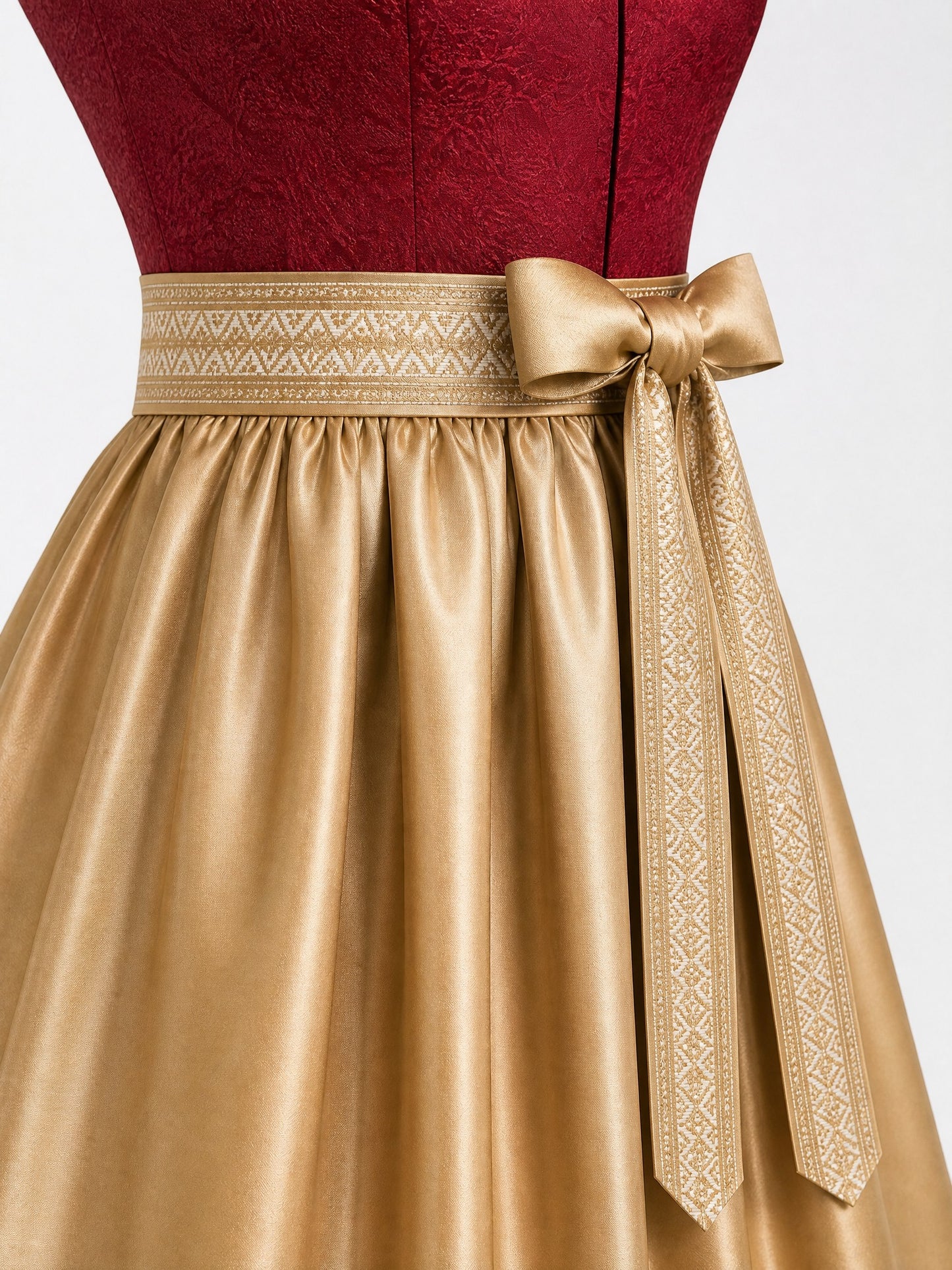 Dirndl Lia in Cranberryrot mit Antikgold Schürze - Detailansicht Taille und Schleife